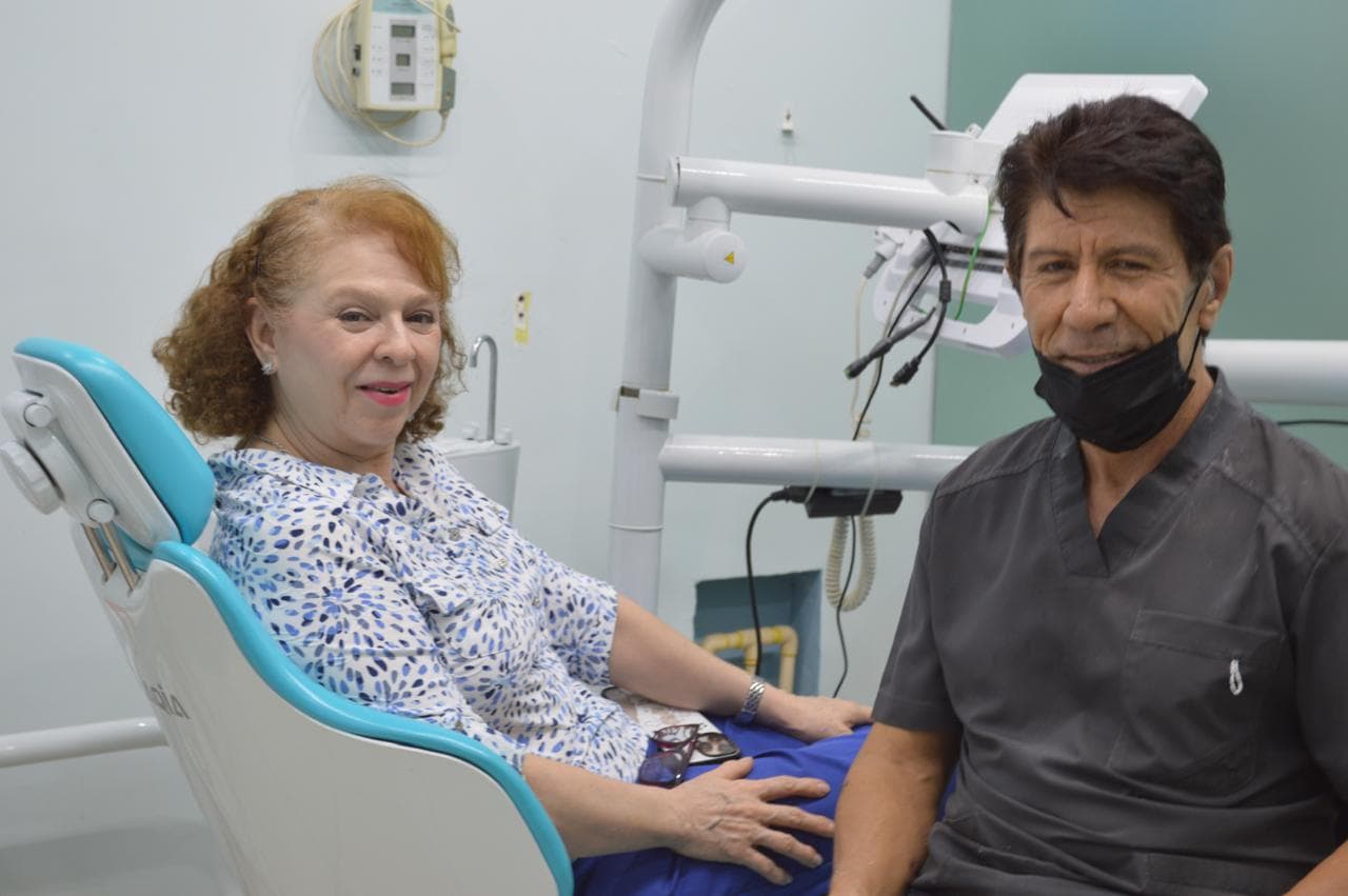 Dr. Lara Zarate junto a paciente sonriente en el sillón dental